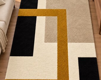 Puede incluir: Una alfombra rectangular con un patrón geométrico de bloques en negro, crema, amarillo mostaza y beige. La alfombra tiene una construcción de pelo grueso y texturizado, mostrando una disposición moderna de formas sólidas y líneas.