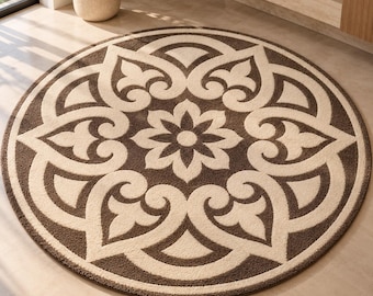 Op de afbeelding: Een rond vloerkleed met een symmetrisch bloemmotief in donkerbruin en crème. Het ontwerp bestaat uit een centrale stervormige bloem omringd door herhalende, gebogen bloemblaadjes in een radiale, mandala-achtige opstelling.