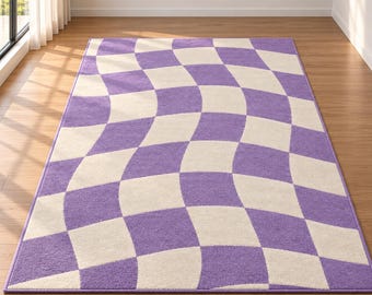 Op de afbeelding: Een rechthoekig vloerkleed met een herhalend dambordpatroon met een vervormd, golvend effect. Het kleed is samengesteld uit afwisselende vierkanten in een levendige paarse tint en een zachte gebroken witte kleur, wat een dynamische, vloeiende textuur creëert.