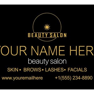 May include: A rectangular black business card featuring gold text and a circular logo with a star icon. The card displays the text BEAUTY SALON, YOUR NAME HERE, beauty salon, SKIN, BROWS, LASHES, FACIALS, www.youremailhere, and +1(555) 234-8890.