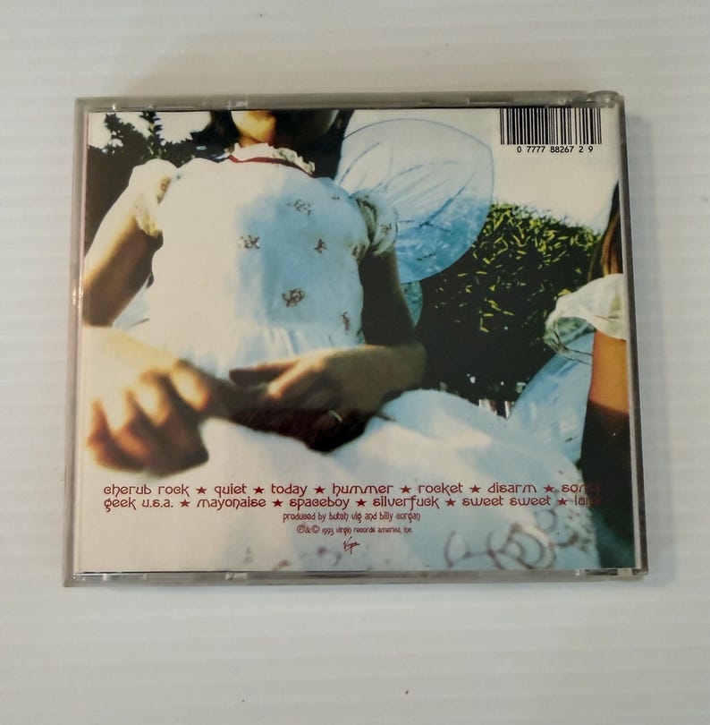 May include: A compact disc case featuring album art with a person in a white dress with angel wings. The tracklist includes "eherub rock", "quiet", "today", "hummer", "rocket", "disarm", "geek u.s.a.", "mayonaise", "spaceboy", "silverfuck", "sweet sweet", and "la".
