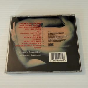 May include: A CD case featuring the album cover with a blurred image of a person's face and arm. The tracklist includes "Dead & Bloated," "Sex Type Thing," and "Wicked Garden." The CD case also includes the Atlantic Recording Corporation logo.
