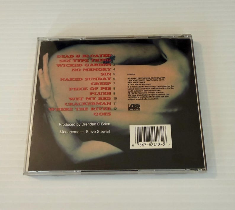 May include: A CD case featuring the album cover with a blurred image of a person's face and arm. The tracklist includes "Dead & Bloated," "Sex Type Thing," and "Wicked Garden." The CD case also includes the Atlantic Recording Corporation logo.