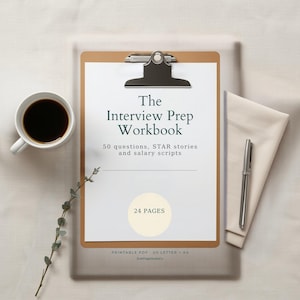 Könnte beinhalten: Ein braunes Klemmbrett mit einem weißen Dokument mit dem Titel The Interview Prep Workbook mit 50 questions, STAR stories and salary scripts, einem 24 pages Kreis, einer Tasse schwarzem Kaffee, einem silbernen Stift und einem grünen Zweig.