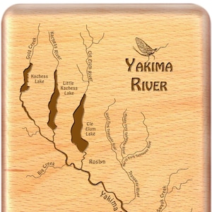 May include: A wooden map of the Yakima River in Washington state. The map shows the river's course, tributaries, and surrounding lakes. The text "YAKIMA RIVER" is prominently displayed at the top of the map.