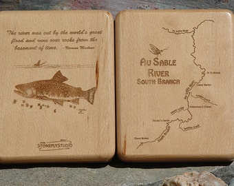 May include: A wooden box with a map of the Au Sable River South Branch on one side and a quote about the river on the other side. The quote reads, "The river was cut by the world's great flood and runs over rocks from the basement of time." - Norman Macdonn