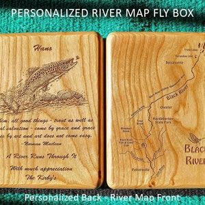 May include: A personalised wooden fly box with a trout illustration and a quote by Norman Maclean. The other side of the box features a map of the Black River with the text "Black River" and a fly.