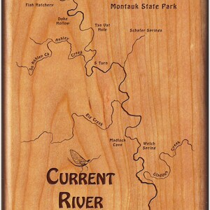 May include: A wooden plaque with a map of the Current River, a popular fishing spot in Missouri. The map shows the location of various features, including Montauk Springs, Duke Hollow, Tan Vat Hole, Schafer Springs, S Turn, Big Creek, Madlock Cave, Welch Spring, and Gladden Creek. The plaque also features the text "CURRENT RIVER" and a silhouette of a mayfly.