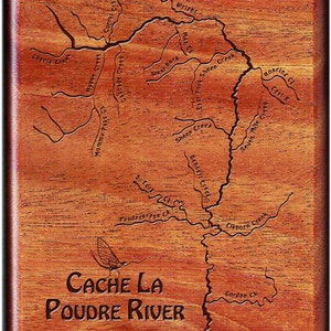 May include: A wooden plaque with a map of the Cache La Poudre River in Colorado. The map shows the river and its tributaries, including Sheep Creek, Roaring Creek, and Seven Mile Creek. The plaque also features the text "CACHE LA POUDRE RIVER" and a small image of a mayfly.