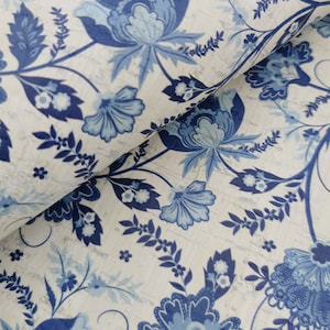 May include: Blue and white floral patterned fabric with a textured background. The fabric features a repeating pattern of stylised flowers and leaves.