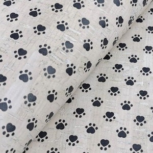 May include: White cork fabric with a repeating pattern of black paw prints.
