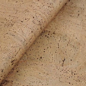 May include: Close-up of a sheet of natural cork material with a light brown colour and a speckled texture.