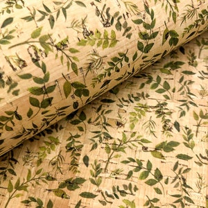 May include: A close-up of cork fabric with a printed pattern of green leaves on a beige background.