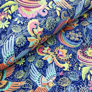 May include: A vibrant fabric with a detailed paisley and floral pattern. The design features colorful birds, flowers, and leaves in shades of blue, green, yellow, orange, and pink. The fabric is rolled, showing the pattern's repeating design.