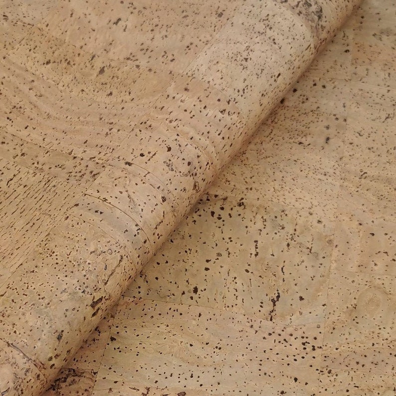 May include: Close-up of a sheet of natural cork material with a light brown colour and a speckled texture.