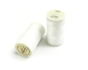 May include: Two white thread spools, one lying down and the other standing. The spools are filled with white thread. The top of one spool reads "100 100M 100% Polyester". The other spool has text that reads "Amore N50".