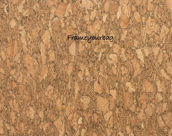 May include: A close-up of a cork board with a natural brown and beige color. The cork board has a textured surface with a pattern of small, irregular shapes. The text "Frameyourbag" is written in black ink on the cork board.