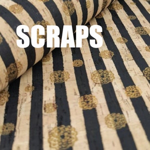 Könnte beinhalten: Schwarzer und beiger gestreifter Korkstoff mit goldenem Blumenmuster. Der Stoff trägt den Schriftzug "SCRAPS".