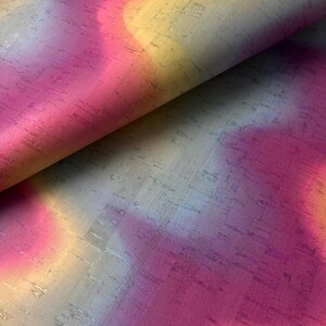 May include: A close-up of a cork fabric with a tie-dye pattern in shades of pink, yellow, and blue.