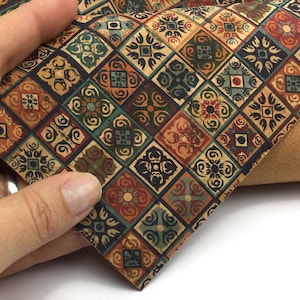 Può includere: Un foglio di tessuto di sughero con un motivo a piastrelle colorate. Le piastrelle hanno un motivo geometrico con motivi floreali. Il tessuto ha un aspetto rustico e vintage.