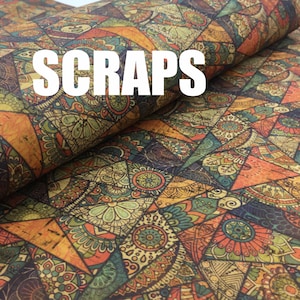 May include: A close-up of a fabric with a colourful, intricate pattern. The fabric is folded in half, and the word "SCRAPS" is printed in white letters on the top fold.