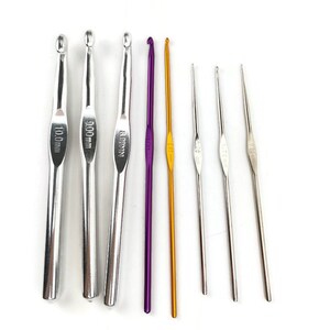May include: A set of eight crochet hooks in various sizes, including 3.5 mm, 4.0 mm, 5.0 mm, 6.0 mm, 8.0 mm, 9.0 mm, and 10.0 mm. The hooks are made of metal and have a silver, gold, and purple finish.