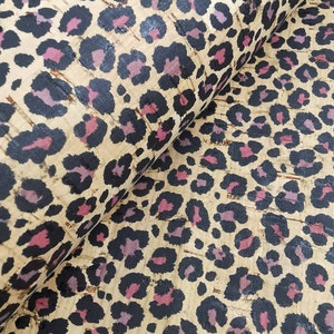 Peut inclure: Tissu en liège avec un motif léopard noir, rose et beige.