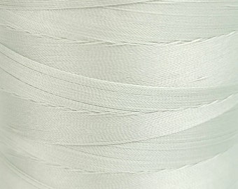 May include: A close-up of a spool of light gray thread.