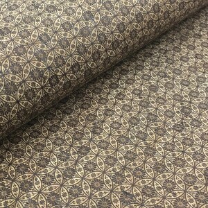 Può includere: Primo piano di un tessuto con un motivo ripetitivo di cerchi marroni e fiori su uno sfondo beige.