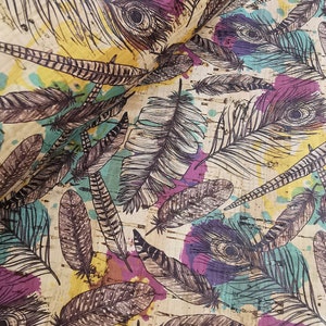 Può includere: Un tessuto in sughero con un motivo di piume bianche e nere e schizzi di acquerello colorati. Le piume sono disposte in modo casuale e i colori sono vivaci e vibranti.