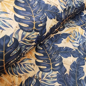 May include: A close-up of a fabric with a tropical leaf pattern. The fabric is beige with dark blue leaves and a cork-like texture.