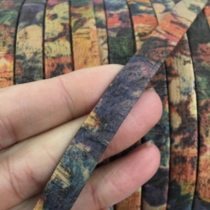 Puede incluir: Primer plano de una cinta de corcho colorida con un patrón azul, verde y rojo. La cinta es fina y flexible, y es perfecta para agregar un toque de belleza natural a las manualidades y los proyectos.