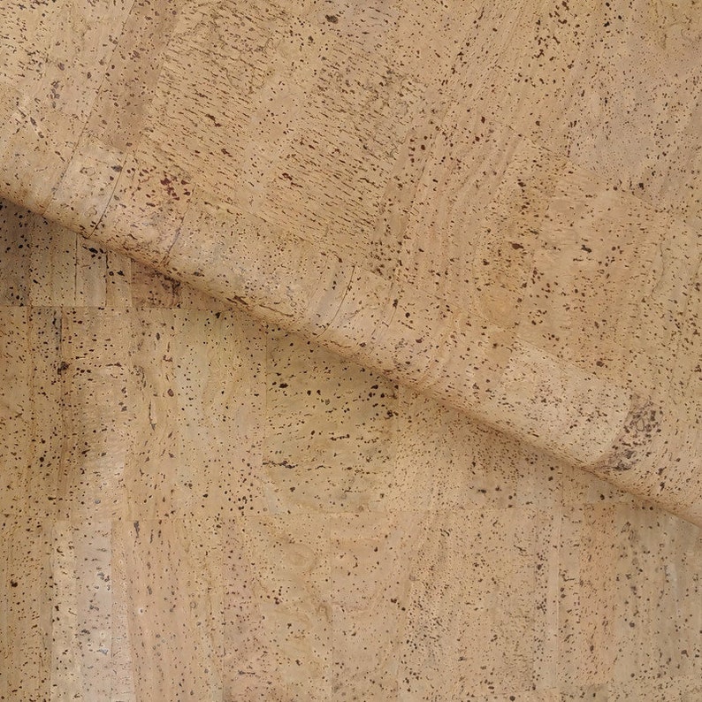 May include: A close-up of a sheet of natural cork with a light brown colour and a textured surface.