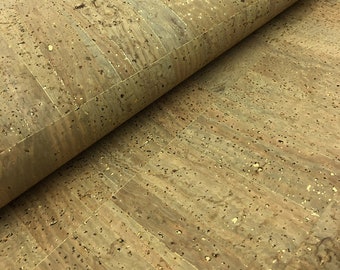 May include: Close-up of a roll of cork material. The cork has a natural, light brown color with darker speckles and subtle gold flecks. The material is textured and appears to be in a rectangular tile pattern.