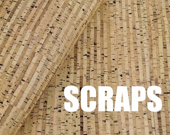 May include: Close-up of cork material with vertical grain. The image shows a roll of cork with the word "SCRAPS" in white block letters. The cork has a natural, light brown color with darker flecks.