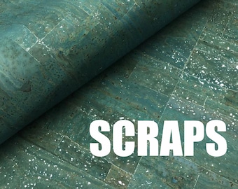 May include: A close-up of a teal and silver cork sheet with the word "SCRAPS" printed in white letters.
