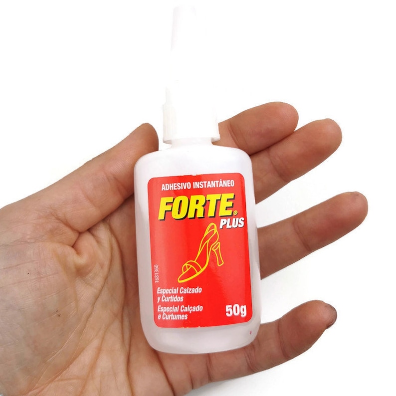 May include: A clear plastic bottle of Forte Plus instant adhesive, labelled "ADHESIVO INSTANT&Aacute;NEO FORTE PLUS" in red and yellow lettering. The bottle is 50g and has a red label with a picture of a high-heeled shoe. The label also says "Especial Calzado y Curtidos" and "Especial Cal&ccedil;ado e Curtumes".