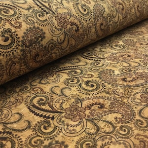 Op de afbeelding: Een close-up van kurk stof met een paisley patroon in tinten van bruin, zwart en groen.