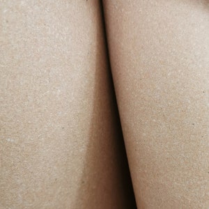 May include: Close-up of two pieces of brown cardboard, showing the texture of the paper.