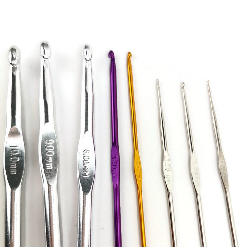 May include: A set of eight crochet hooks in various sizes and colors, including silver, purple, and gold. The hooks are labeled with their size in millimeters, ranging from 3.5 mm to 10.0 mm.