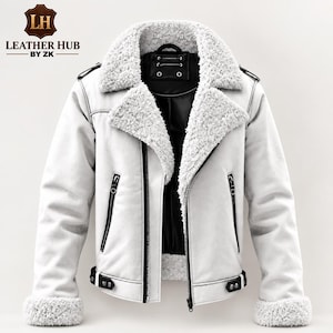 Pode incluir: Uma jaqueta branca com gola e punhos grossos de pele sintética branca. A jaqueta apresenta fechos de zíper pretos, detalhes de acabamento pretos e um forro interno preto. O texto LEATHER HUB BY ZK está impresso no canto superior esquerdo.