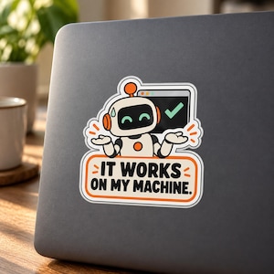 May include: A die-cut sticker featuring a cartoon robot with orange accents, shrugging with a sweat drop, next to a computer window with a green checkmark. Below the robot, an orange-bordered sign displays the text IT WORKS ON MY MACHINE.