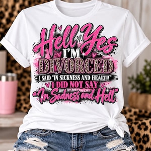 Puede incluir: Una camiseta blanca con un diseño gráfico en texto rosa brillante que dice Hell Yes I'M DIVORCED, I SAID IN SICKNESS AND HEALTH, I DID NOT SAY In Sadness and Hell. La palabra DIVORCED tiene un estampado de leopardo y corazones rosas.