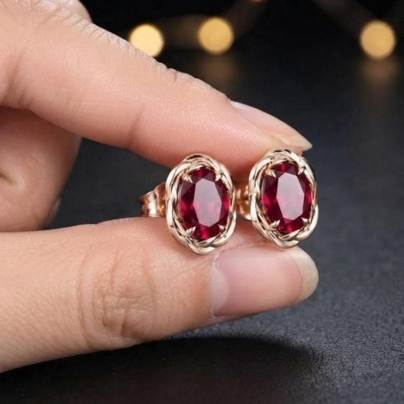 Peut inclure: Une paire de boucles d'oreilles &agrave; clous avec des pierres pr&eacute;cieuses rouge fonc&eacute; de taille ovale, serties dans une monture en m&eacute;tal or rose torsad&eacute;. Les boucles d'oreilles pr&eacute;sentent une finition polie et un fermoir &agrave; tige s&eacute;curis&eacute;.
