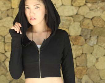 Könnte beinhalten: Ein schwarzer, kurzer Hoodie mit Reißverschluss und Kapuze. Der Hoodie ist aus weichem, bequemem Stoff und hat eine lockere Passform.