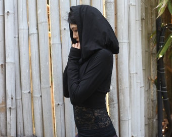 May include: A black hooded top with long sleeves and a cropped hem. The top is made of a soft, stretchy fabric and has a relaxed fit.