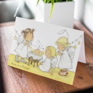 Nativity Christmas Card – Cute Angel Scene with Baby Jesus – Religious Xmas Card – Away in a Manger – Single or Multipack  XMAS9821