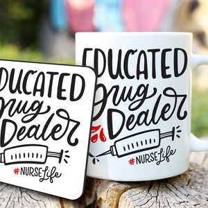 May include: A white ceramic mug and coaster set with the text "EDUCATED Drug Dealer" in black script. The design includes a syringe graphic and the hashtag "#NURSE Life" in red and black. The items are displayed on a wooden surface.