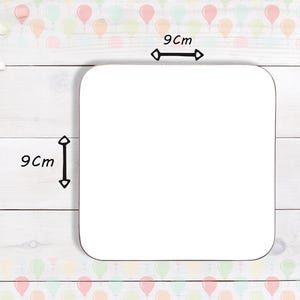 May include: A square, white coaster with rounded corners, measuring 9 cm by 9 cm. The coaster is blank, ready for customization. The background features a light wood grain pattern and a border of colorful balloons.