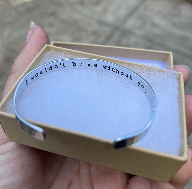 Puede incluir: Un brazalete de plata con la inscripci&oacute;n "Yo no ser&iacute;a yo sin ti". El brazalete est&aacute; en una peque&ntilde;a caja blanca.